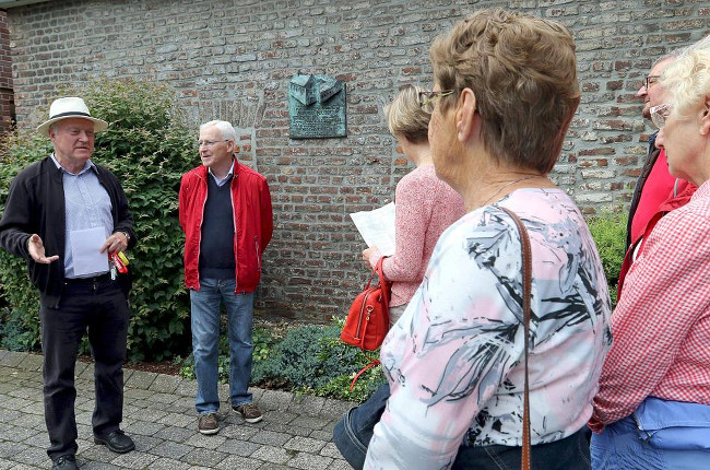 Sepp Becker (l.) berichtete am früheren Kloster neben der Sparkasse - eine Hinweistafel erinnert an die Geschichte - über das Wirken der Kapuziner in Wassenberg. FOTO: Laaser